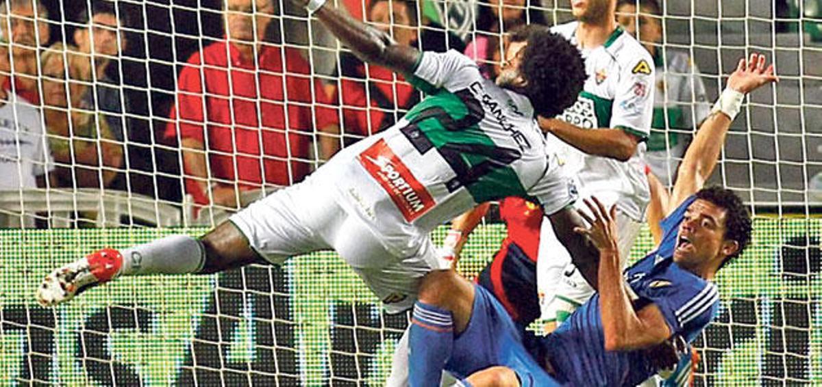 Carlos Sánchez, del Elche, y Pepe, con la equipación azul del Real Madrid, caen en el área durante la acción del penalti de 2013.