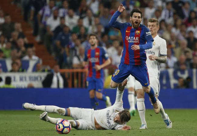 Messi salta mientras Sergio Ramos se desliza en la acción que acabó con la expulsión del capitán madridista.